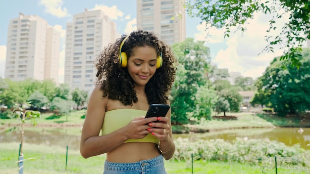 Mulher latina usando smartphone no parque. menina brasileira.