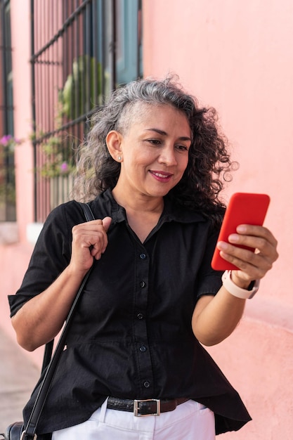 Mulher latina usando telefone celular na rua