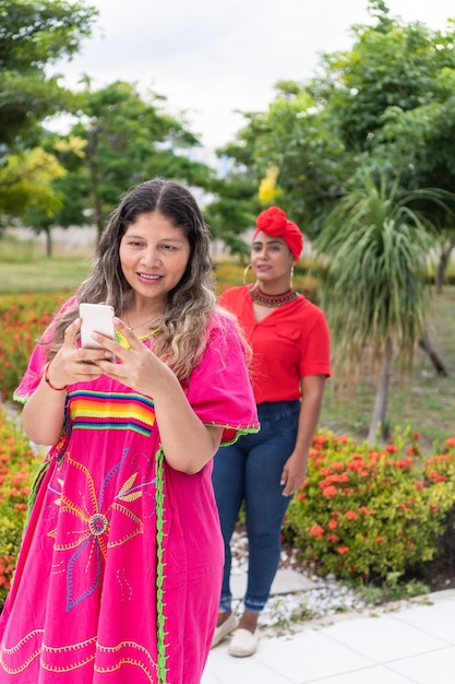 Mulher latina usando um telefone celular e esperando sua amiga