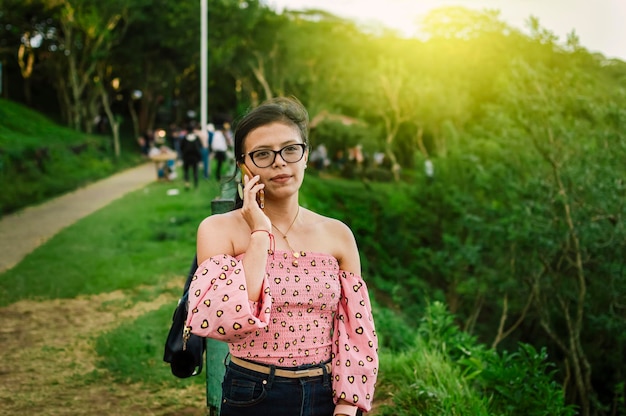 Mulher latina verificando o celular, menina bonita de óculos verificando o celular