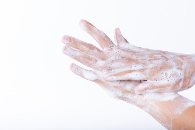 Mulher lavando as mãos com sabão no fundo branco. conceito de saúde.