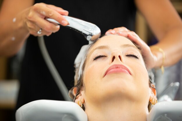 Mulher lavando cabelo em salão de cabeleireiro