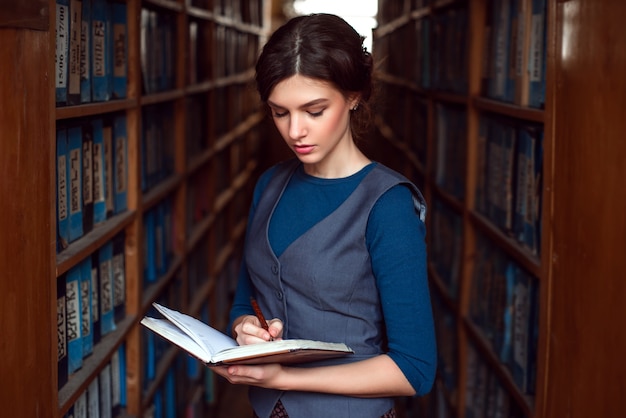 Mulher lendo em uma biblioteca.