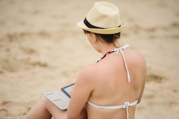 Foto mulher lendo leitor de tablet na praia