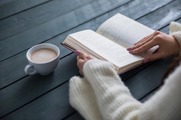 Mulher lendo livro com café