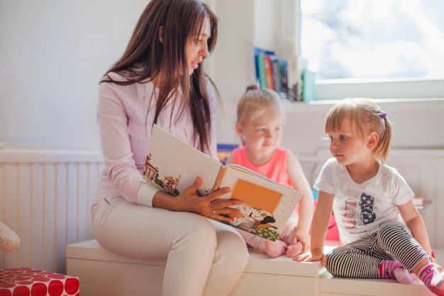 Foto mulher lendo livro para menina