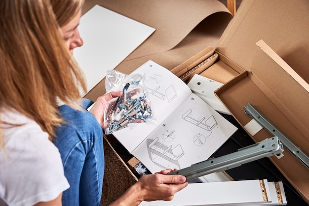 Mulher lendo manual de instruções para montar móveis