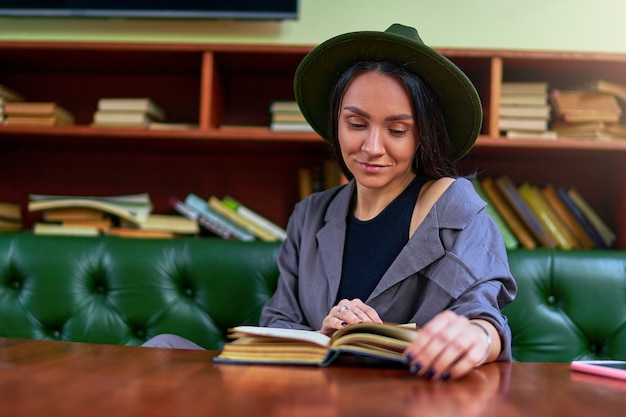 Mulher lendo na moda elegante descansando sozinha e curtindo um livro de romance romântico na loja da biblioteca