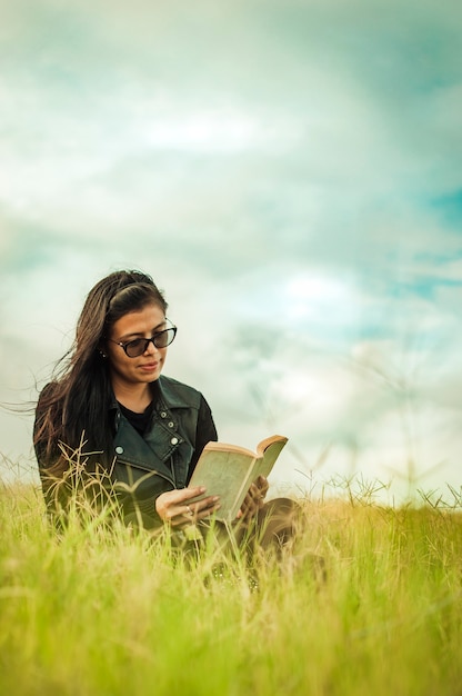 Mulher lendo no campo, menina lendo um livro com espaço de cópia