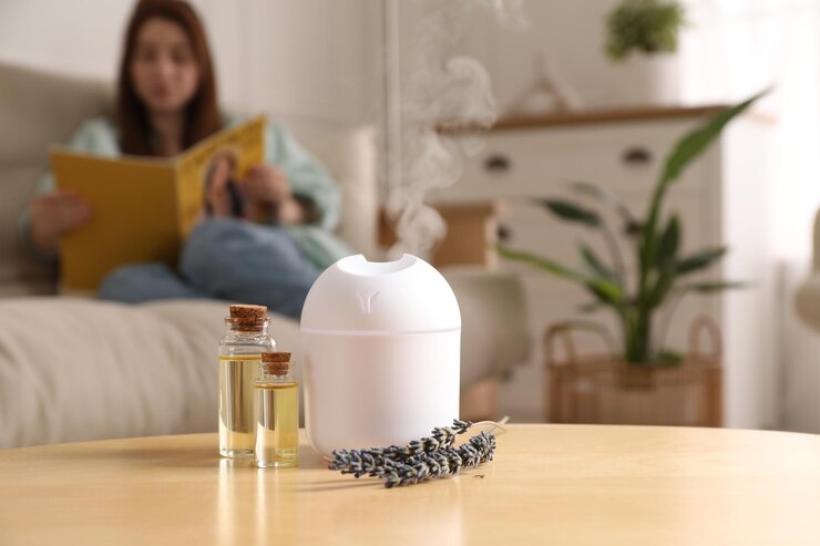 Foto mulher lendo revista em casa se concentra em garrafas de difusor de aroma de óleos essenciais e flores de lavanda