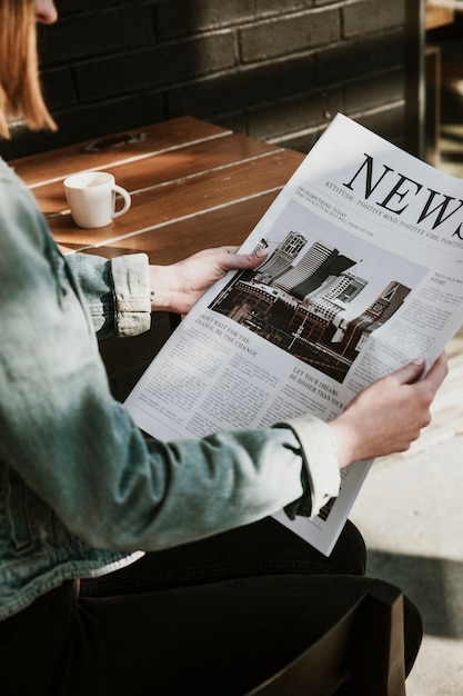 Mulher lendo um jornal em um café
