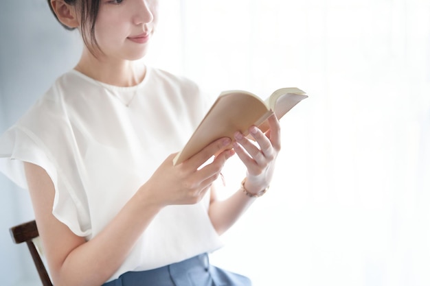 Mulher lendo um livro dentro de casa