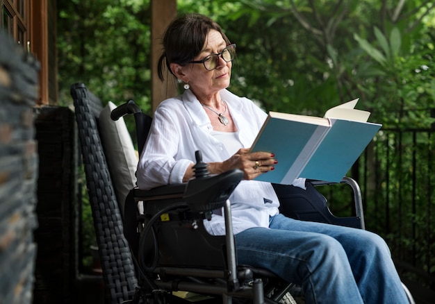 Mulher, lendo um livro, em, um, cadeira rodas