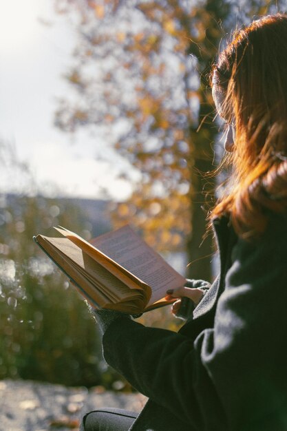 Foto mulher lendo um livro em um parque foto