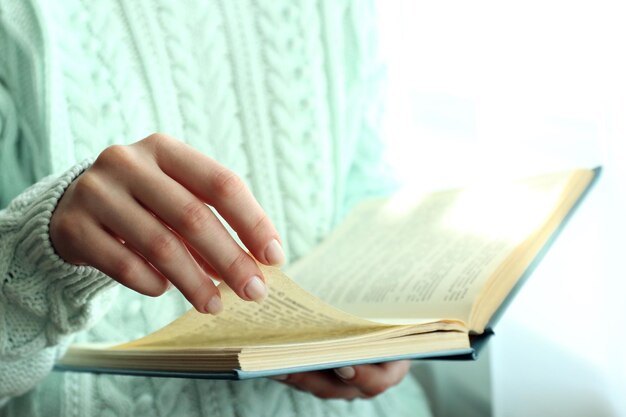 Mulher lendo um livro perto da janela