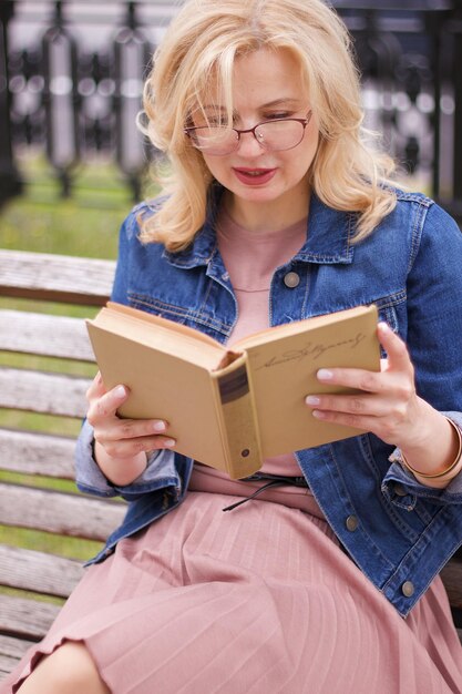 Mulher lendo um livro sentada ao ar livre