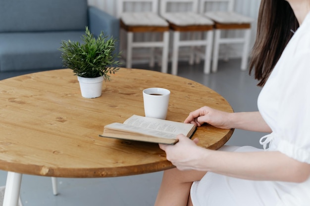 Mulher lendo um livro sentado em uma mesa de café