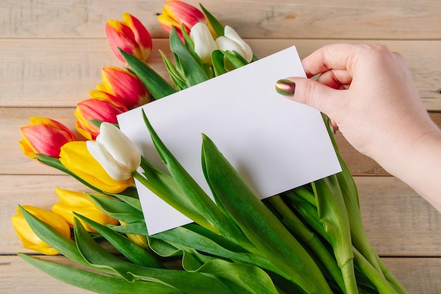Mulher leva cartão de buquê de tulipas Presente de feriado Símbolo de primavera