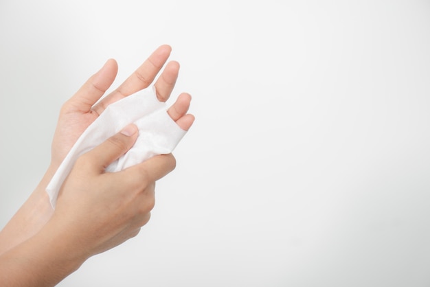 Mulher limpando as mãos com um lenço de papel no fundo branco