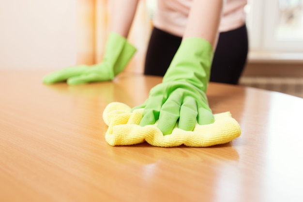 Mulher limpando manchas da mesa, foto de perto