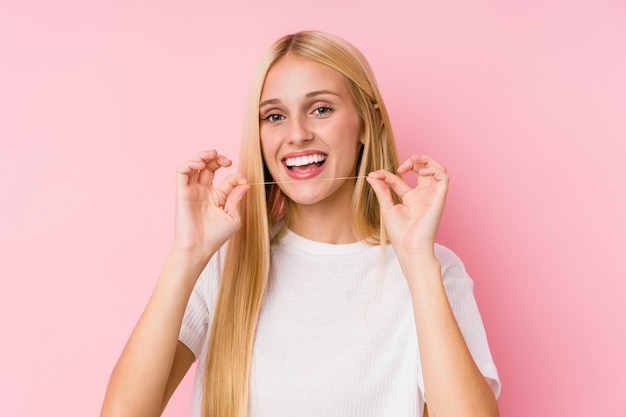 Mulher limpando os dentes com fio dental