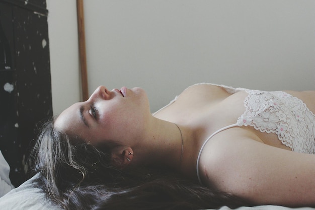 Mulher linda deitada em lingerie na cama em casa