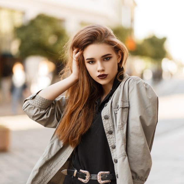 Mulher linda e elegante modelo com uma jaqueta elegante e uma camisa pólo preta na rua