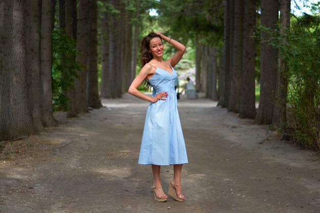 Mulher linda em um vestido azul no parque