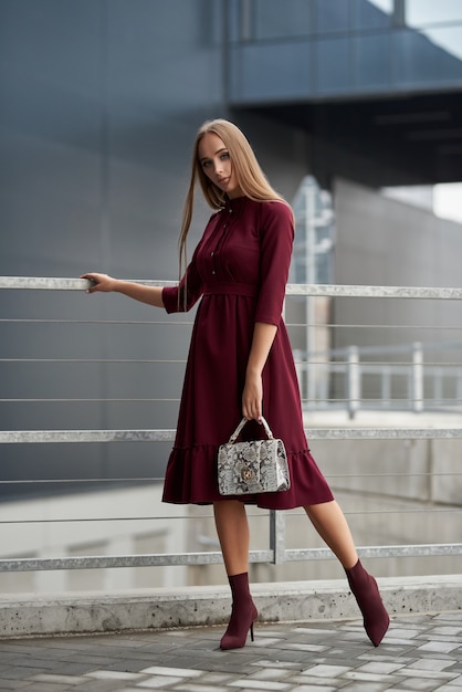 mulher linda em um vestido da moda caminhando pela rua