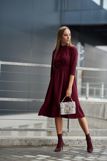 mulher linda em um vestido da moda caminhando pela rua