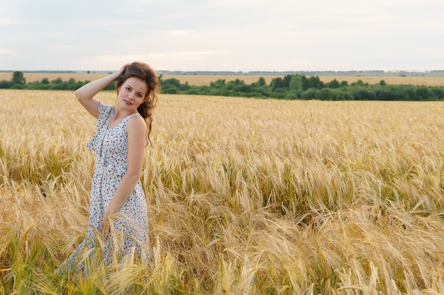 Mulher linda em um vestido em um campo de trigo