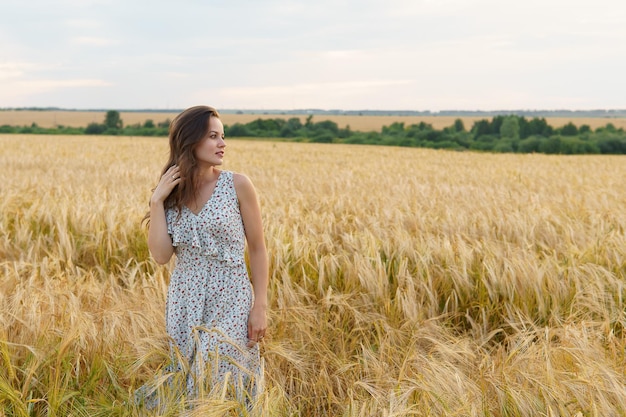 Mulher linda em um vestido em um campo de trigo