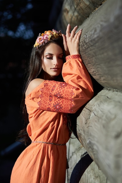 Mulher linda em um vestido laranja com uma coroa de flores