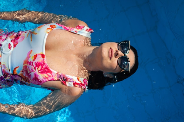 Mulher linda relaxando na piscina