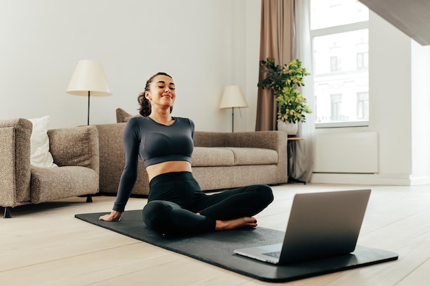 Mulher linda sentada em casa enquanto olha para o laptop