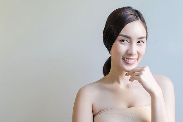 Mulher linda sorridente contra um fundo cinzento