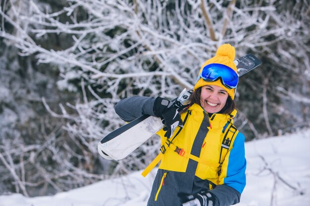 Mulher linda sorridente segurando esqui nas férias de inverno