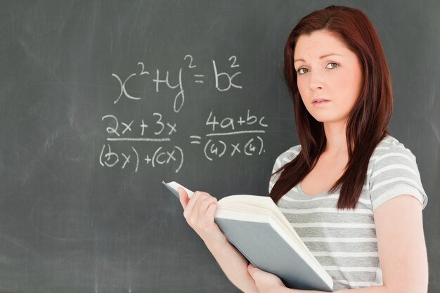 Mulher linda tentando resolver uma equação matemática em um quadro-negro