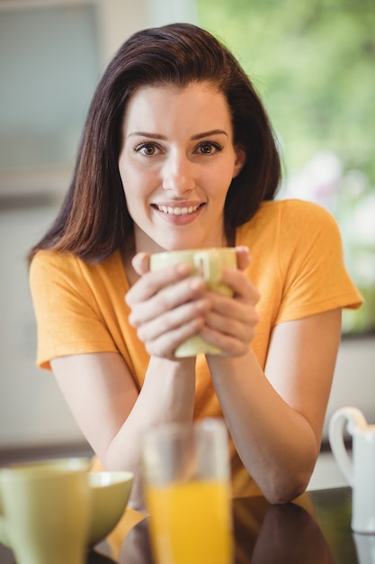 Mulher linda tomando café na cozinha