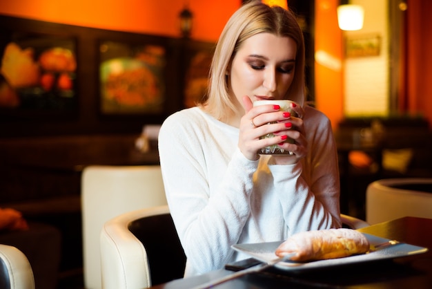 Mulher linda tomando cappuccino em um café