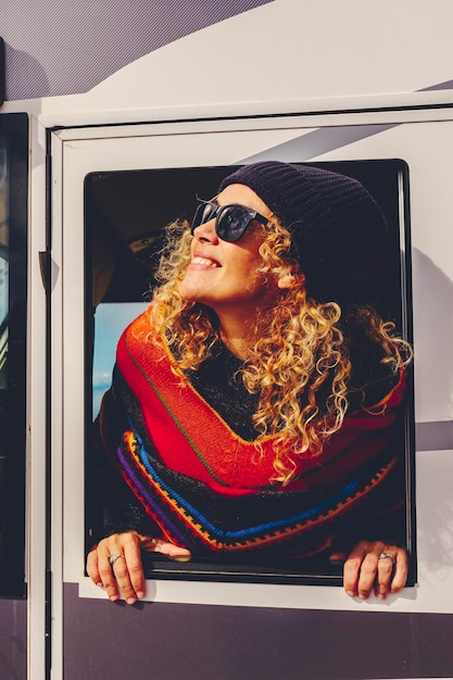 Mulher loira a conduzir uma caravana estacionada e a desfrutar da vista de uma bela paisagem no meio da natureza Conceito de liberdade e férias