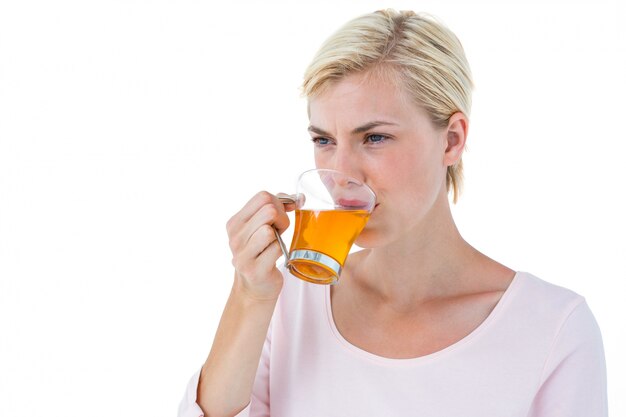 Mulher loira atraente que toma o chá