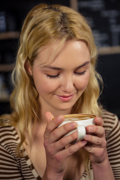 Mulher loira, bebendo uma xícara de café