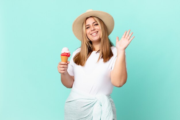 Mulher loira bonita e curvilínea sorrindo feliz, acenando com a mão, dando as boas-vindas e cumprimentando você