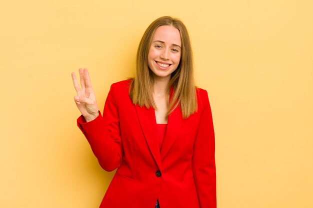 Mulher loira bonita sorrindo e parecendo amigável mostrando o conceito de empresária número três