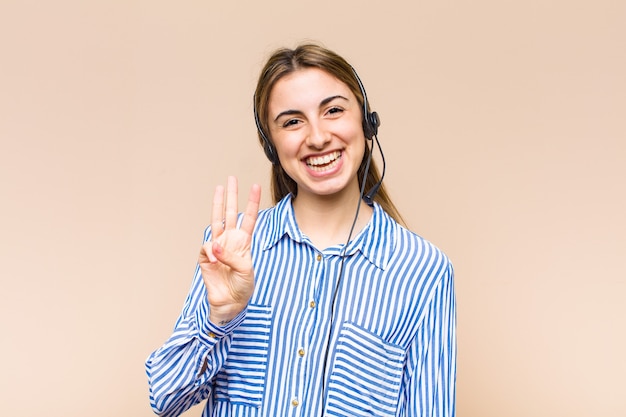 Mulher loira bonita sorrindo e parecendo amigável, mostrando o número um ou primeiro com a mão para a frente, em contagem regressiva