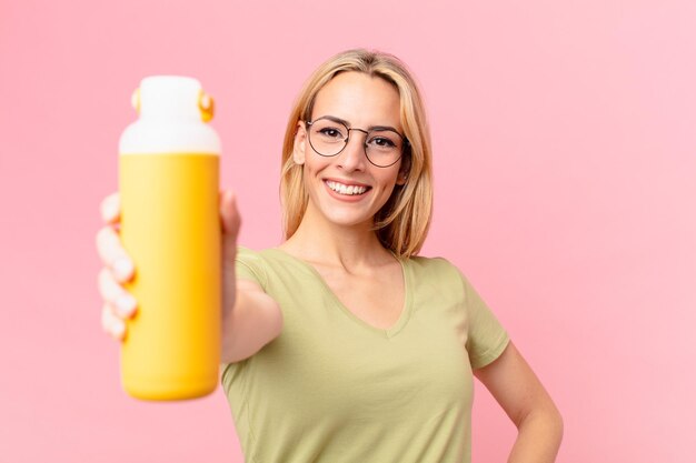 Mulher loira bonita tomando um suco de laranja