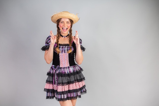 Foto mulher loira brasileira roupas de festa junina arraial boa sorte dedos cruzados
