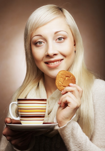 Mulher loira com café e biscoitos