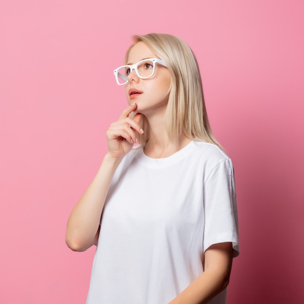 Mulher loira de camiseta branca e óculos